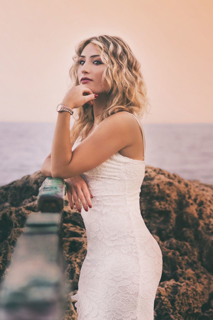 women, adult, one person, water, blond hair, female, young adult, sea, clothing, fashion, hairstyle, beach, land, dress, nature, wedding dress, portrait, long hair, sky, bridal clothing, beauty in nature, looking, bride, gown, sunset, standing, photo shoot, three quarter length, emotion, outdoors, contemplation, lifestyles, copy space, elegance, summer, tranquility, holiday, looking at camera, celebration, vacation, relaxation