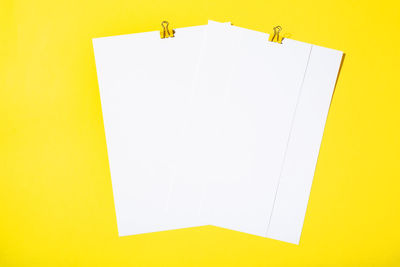 High angle view of paper against yellow background