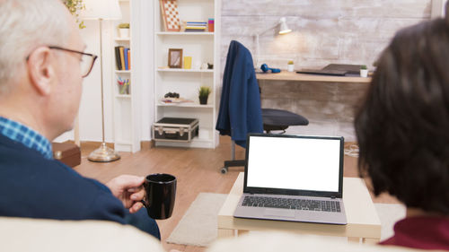 Senior couple looking at computer at home