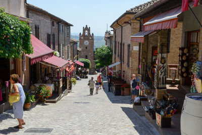 People walking on street amidst buildings in city