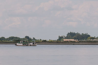 Boat sailing in river against sky