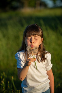 Girl looking away while standing on field