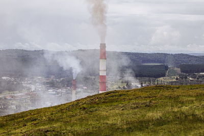 Smoke emitting from chimney against sky