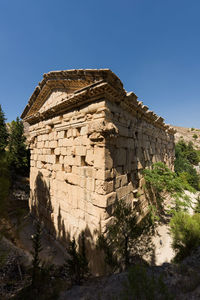 Low angle view of historic temple against clear blue sky