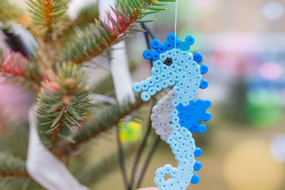 Handmade plastic seahorse decoration on christmas tree outdoors. diy ideas for children