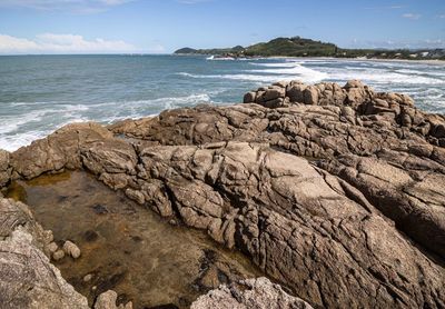 Rock formation on beach against sky