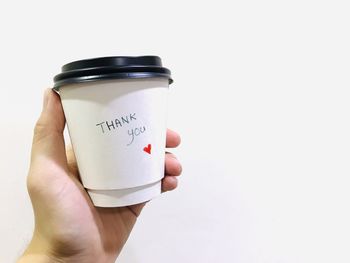 Close-up of hand holding white cup