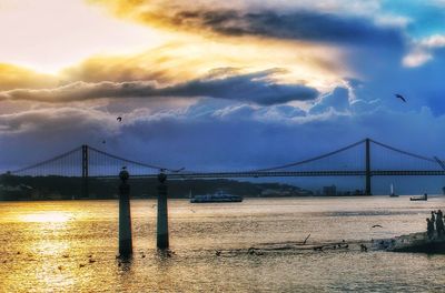 Suspension bridge over river against sky