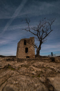 Abandoned house on field against sky