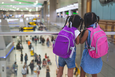 Rear view of siblings standing at airport