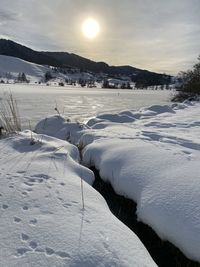 Snow covered landscape against sky