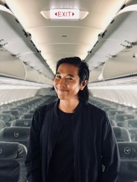 Portrait of smiling man standing in airplane