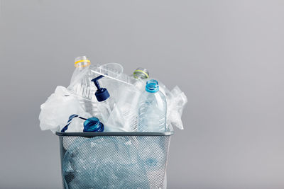 Close-up of garbage in bin against gray background