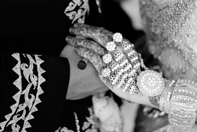 Midsection of bride holding wedding dress