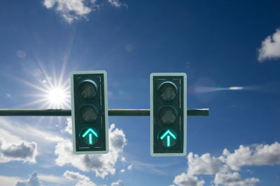 Low angle view of road signal against blue sky