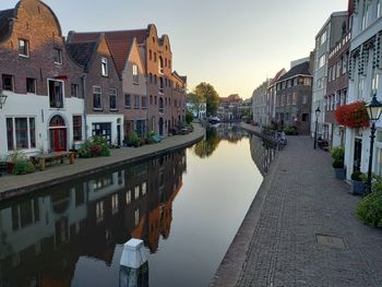 Canal amidst buildings against sky