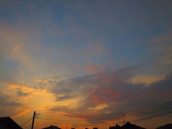 Low angle view of silhouette electricity pylon against sky during sunset