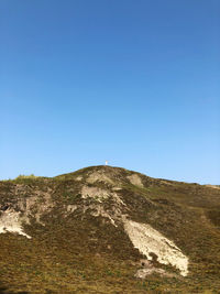 Low angle view of mountain against clear blue sky