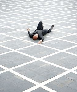 High angle view of woman sitting on tiled floor