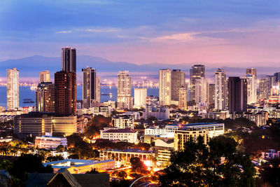 Illuminated buildings in city against sky