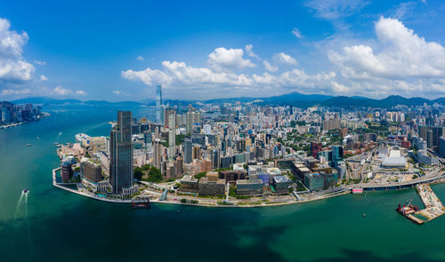 Aerial view of city by sea against sky