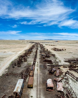 Abandoned bus on land against blue sky