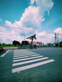 Zebra crossing on road against sky