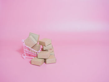 High angle view of paper box against pink background