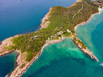 Top view of island and beautiful blue seashore and rocky on coast and white bungalow on the beach