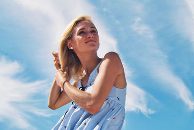 Low angle view of woman standing against sky