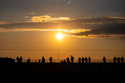 Silhouette people against sky during sunset