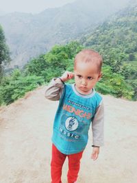 Portrait of cute boy standing on land