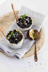 Close up photo of two glass filled with blueberry puddings.