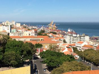 High angle view of cityscape by sea against clear sky