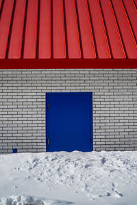 Red structure on snow against sky