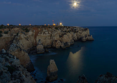 Rock formations by sea against sky