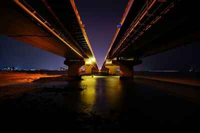 Suspension bridge over river at night