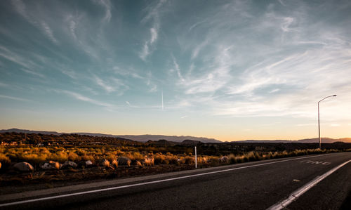 Road by landscape against sky