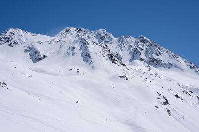 Scenic view of snowcapped mountains against clear blue sky