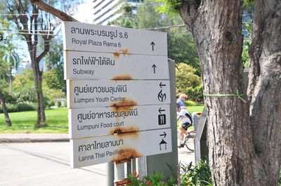 Close-up of road sign by tree trunk