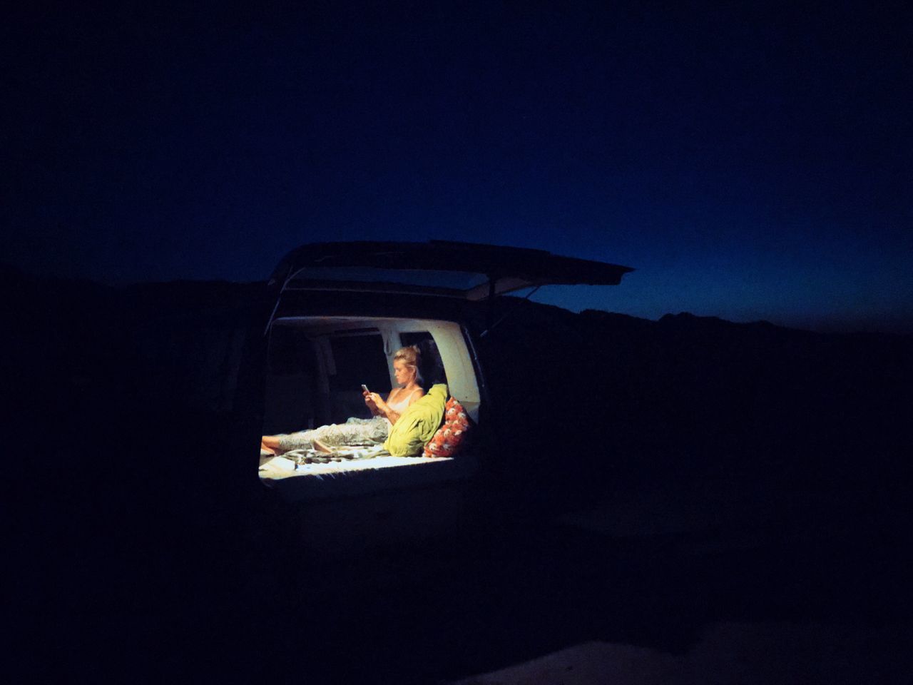 REAR VIEW OF WOMAN SITTING AT NIGHT IN SKY