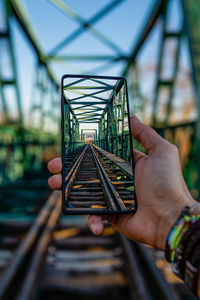 Close-up of person hand on railroad track