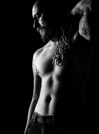 Full length of shirtless man against black background