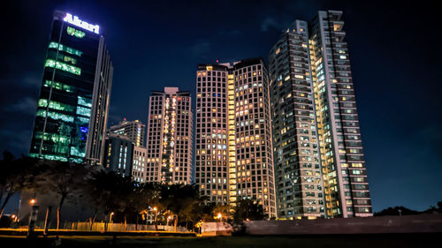 Low angle view of illuminated buildings against sky at night