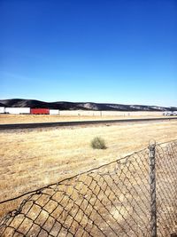 Scenic view of field against clear blue sky