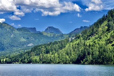 Scenic view of lake by trees against sky