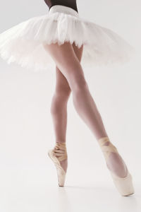 A photo of a ballerina's legs in pointes showing a pa during a performance