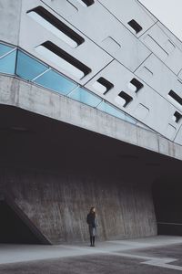 Full length rear view of man walking on road in city