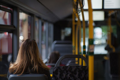 Rear view of woman sitting in bus