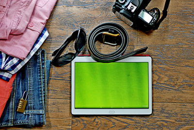 Directly above shot of technologies and personal accessories on wooden table